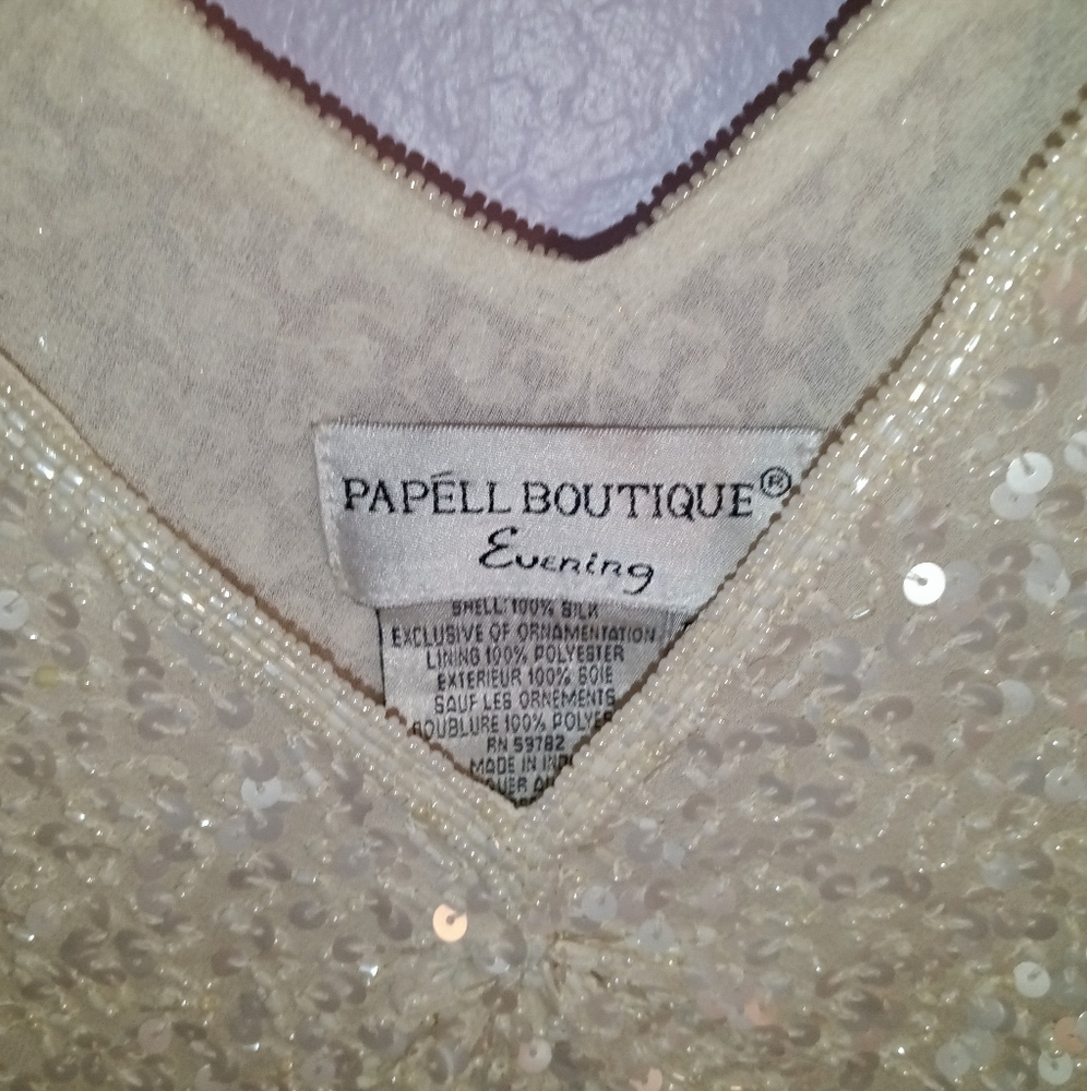 Medium shirt, creme colored with sequins and shoulder opening.
